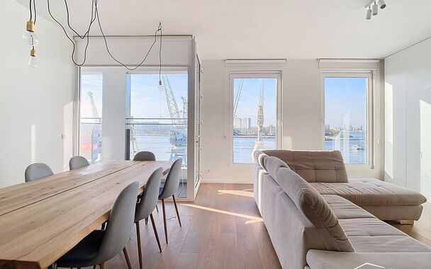 Hedendaags volledig gerenoveerd appartement (ca 75m²) met frontaal uitzicht op de Schelde in een monumentaal gebouw op het Eilandje. Woon- en eetkamer (ca. 30m²) op parket met open ingerichte keuken met eiland voorzien van kookplaat, dampkap, combi oven