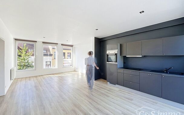 Mooi appartement op de tweede verdieping met een riant terras. Inkomhal, lichtrijke leefruimte (ca 37m&sup2;) met een open ge&iuml;nstalleerde keuken. De moderne keuken is uitgerust met keramische kookplaat, oven, dampkap, vaatwasser en koelkast met vriesvak. Van