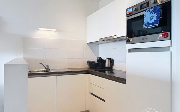 Dit energiezuinig appartement bevindt zich in een recent gebouw (2018) nabij de Slachthuissite. U betreedt het appartement via de inkomhal (ca.7 m&sup2;) met voldoende kastruimte en apart toilet. Lichtrijke woonkamer op keramische parket met een open keuken. 
