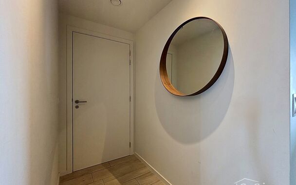 Dit energiezuinig appartement bevindt zich in een recent gebouw (2018) nabij de Slachthuissite. U betreedt het appartement via de inkomhal (ca.7 m&sup2;) met voldoende kastruimte en apart toilet. Lichtrijke woonkamer op keramische parket met een open keuken. 