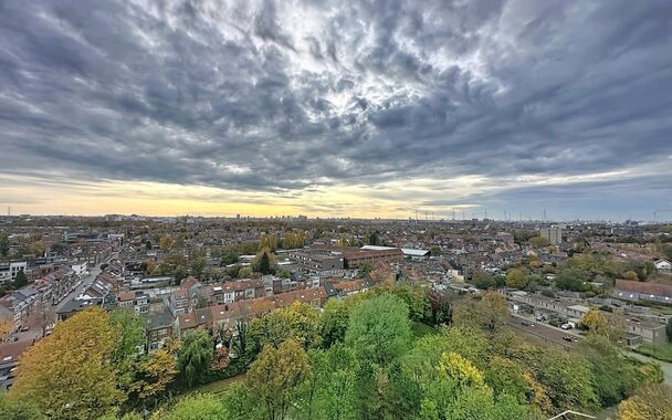 Dit lichtrijke appartement op de 14de verdieping biedt een uniek panoramisch uitzicht over de skyline van Antwerpen. Bij binnenkomst word je verwelkomd in een ruime inkomhal met praktische maatkast en directe toegang tot alle ruimtes.

De gezellige woonka