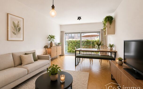 Dit aangename gelijkvloerse appartement combineert een praktische indeling met veel lichtinval en fijne buitenruimtes.
Bij binnenkomst verwelkomt de hal met praktische maatkasten u met heel wat extra opbergruimte. De ruime leefruimte biedt plaats voor een