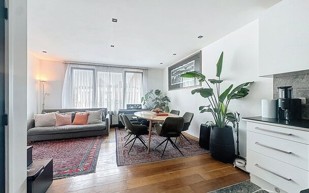 In een charmant gebouw met herenhuis-allure ontdek je deze unieke duplexwoning die eerder dienst deed als twee aparte appartementen, maar nu stijlvol werd samengevoegd tot een ruimtelijke gezinswoning vol karakter.
Via de aparte privé-inkomhal stap je bi