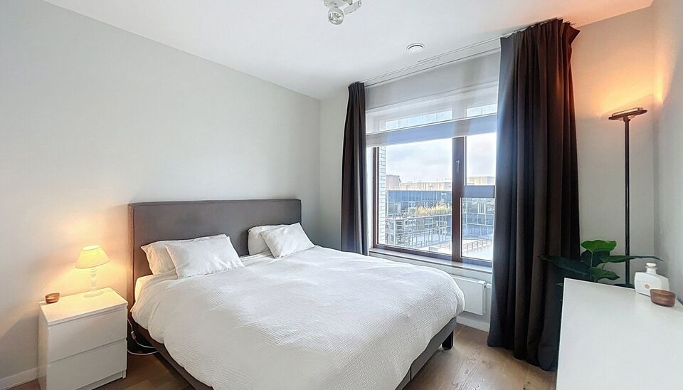 Verzorgd volledig ingericht hoekappartement op de 8e verdieping met een open uitzicht op het MAS en over de Leie. Inkomhal met vestiairekast en apart toilet. Ruime woon- en eetkamer op parketvloer (ca. 36m&sup2;) welke toegang geeft tot het overdekte terras. 