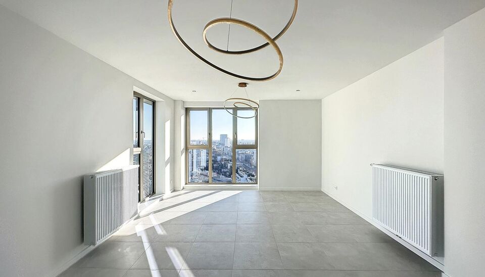 Luxe nieuwbouw appartement op de 20e verdieping met 270 graden uitzicht over Antwerpen, Park Spoor Noord, het Eilandje en de dokken. De lichtrijke leefruimte (ca. 26 m&sup2;) met open  keuken (ca. 6 m&sup2;) is voorzien van een keramische kookplaat, dampkap, koel