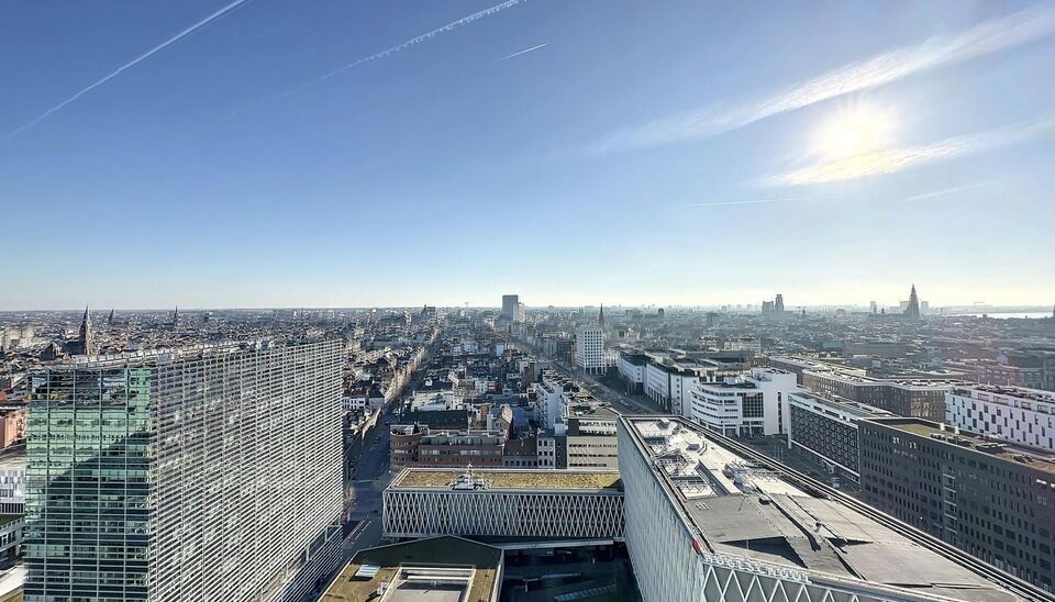 Luxe nieuwbouw appartement op de 20e verdieping met 270 graden uitzicht over Antwerpen, Park Spoor Noord, het Eilandje en de dokken. De lichtrijke leefruimte (ca. 26 m&sup2;) met open  keuken (ca. 6 m&sup2;) is voorzien van een keramische kookplaat, dampkap, koel