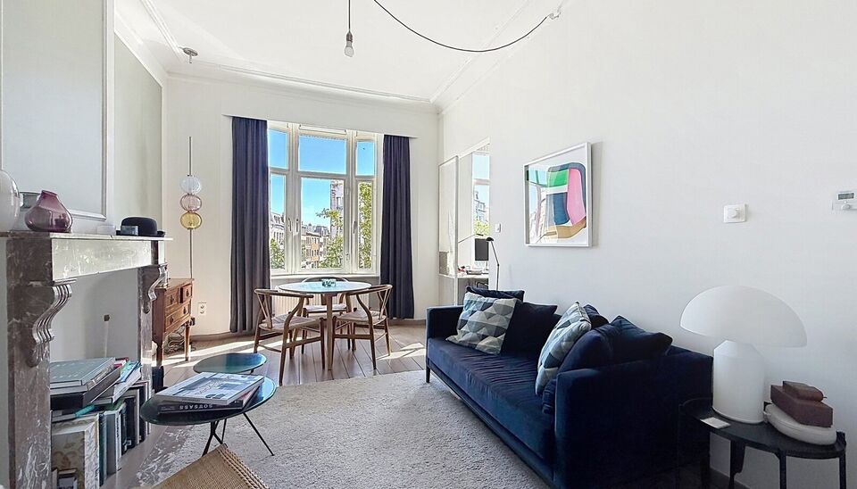 Charmant instapklaar appartement op de 2e verdieping met aangenaam open uitzicht. Inkomhal met vestiairekast. Lichtrijke woonkamer (ca. 22m&sup2;) op authentieke plankenvloer en een schouwelement. Aansluitend de half open keuken voorzien van gasfornuis, dampk
