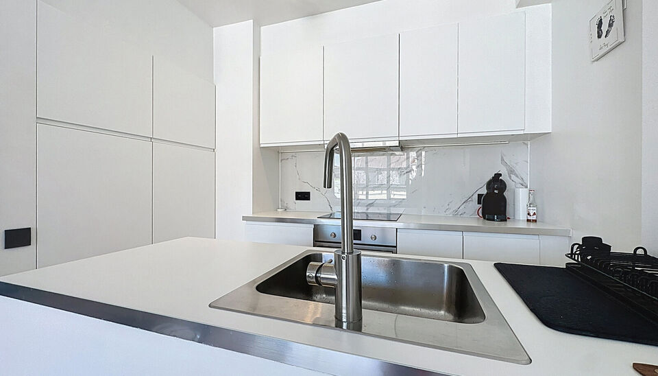 In een kleinschalig en verzorgd gebouw met lift bevindt zich dit prachtig gerenoveerde appartement met hoogwaardige afwerking. De ruime inkomhal beschikt over een bergkast met aansluiting voor wasmachine en droogkast. De lichtrijke woonkamer met grote ram