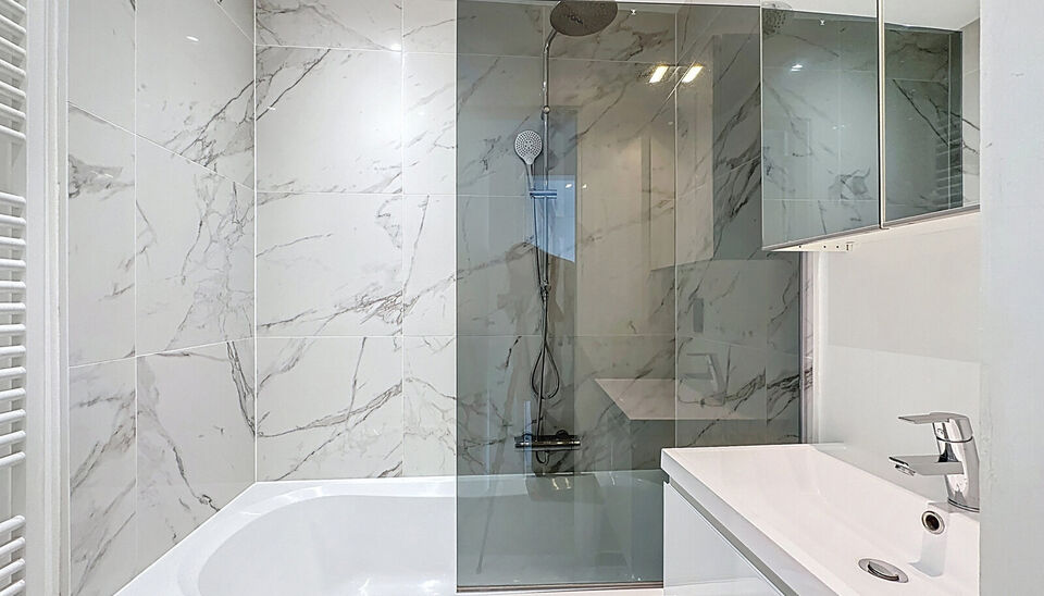 In een kleinschalig en verzorgd gebouw met lift bevindt zich dit prachtig gerenoveerde appartement met hoogwaardige afwerking. De ruime inkomhal beschikt over een bergkast met aansluiting voor wasmachine en droogkast. De lichtrijke woonkamer met grote ram