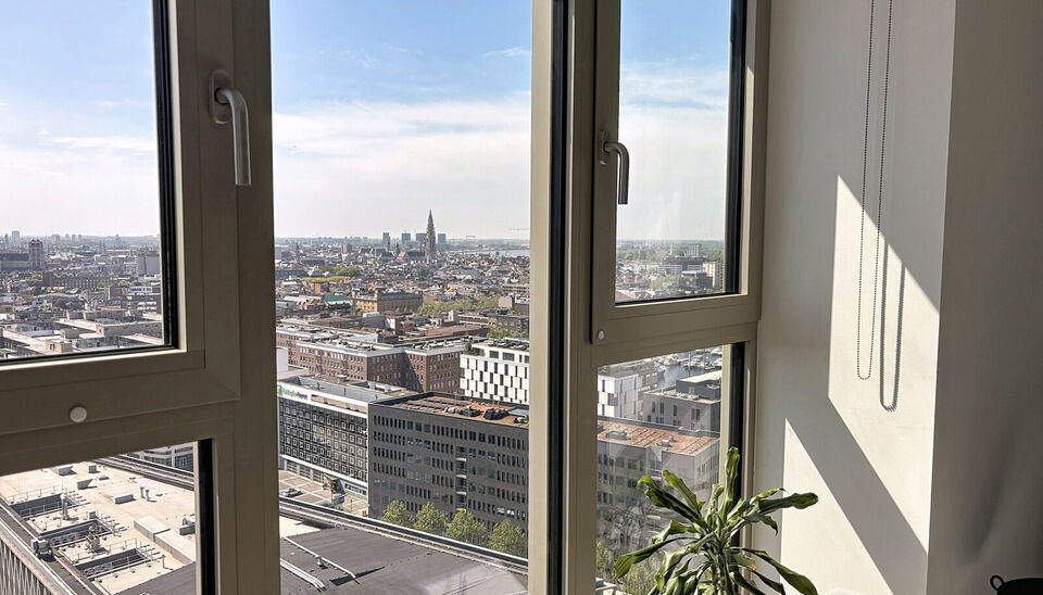 Luxe nieuwbouw appartement op de 20e verdieping met 270 graden uitzicht over Antwerpen, Park Spoor Noord, het Eilandje en de dokken. De lichtrijke leefruimte (ca. 26 m&sup2;) met open  keuken (ca. 6 m&sup2;) is voorzien van een keramische kookplaat, dampkap, koel