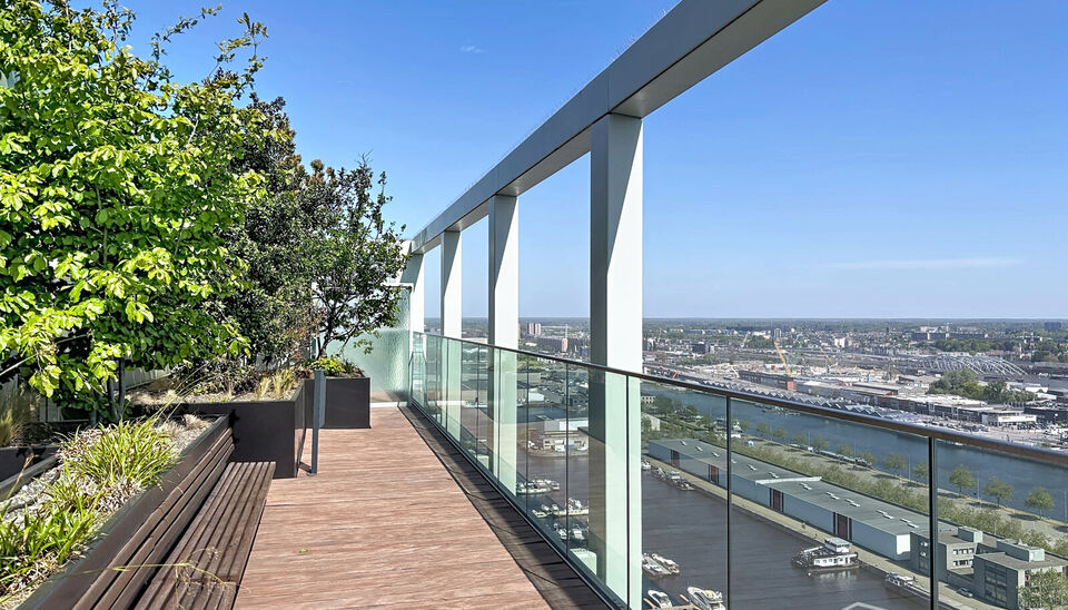 Luxe nieuwbouw appartement op de 20e verdieping met 270 graden uitzicht over Antwerpen, Park Spoor Noord, het Eilandje en de dokken. De lichtrijke leefruimte (ca. 26 m&sup2;) met open  keuken (ca. 6 m&sup2;) is voorzien van een keramische kookplaat, dampkap, koel