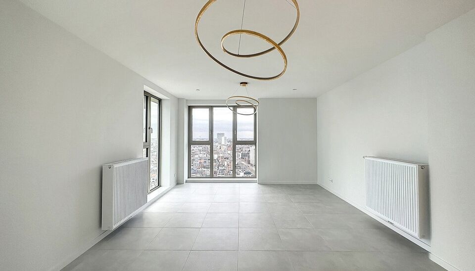 Luxe nieuwbouw appartement op de 20e verdieping met 270 graden uitzicht over Antwerpen, Park Spoor Noord, het Eilandje en de dokken. De lichtrijke leefruimte (ca. 26 m&sup2;) met open  keuken (ca. 6 m&sup2;) is voorzien van een keramische kookplaat, dampkap, koel