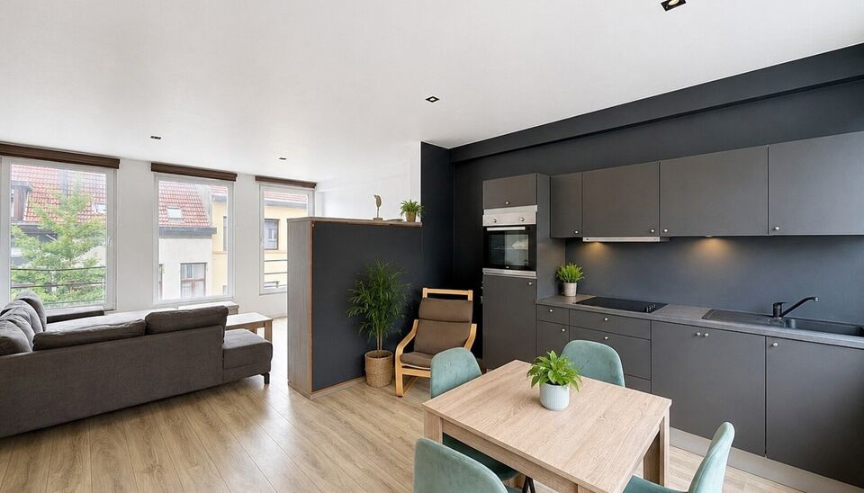 Mooi appartement op de tweede verdieping met een riant terras. Inkomhal, lichtrijke leefruimte (ca 37m&sup2;) met een open ge&iuml;nstalleerde keuken. De moderne keuken is uitgerust met keramische kookplaat, oven, dampkap, vaatwasser en koelkast met vriesvak. Van