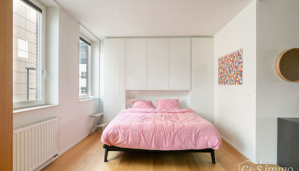 Kwalitatief afgewerkt appartement op de vierde verdieping van &lsquo;Het Koninklijk Entrepot&rsquo;. Men betreedt de woning via de inkomhal, met veiligheidsdeur, die rechtstreeks toegang biedt tot de open en lichtrijke woon- en eetkamer op parket die een frontaal