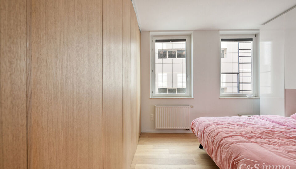 Kwalitatief afgewerkt appartement op de vierde verdieping van &lsquo;Het Koninklijk Entrepot&rsquo;. Men betreedt de woning via de inkomhal, met veiligheidsdeur, die rechtstreeks toegang biedt tot de open en lichtrijke woon- en eetkamer op parket die een frontaal