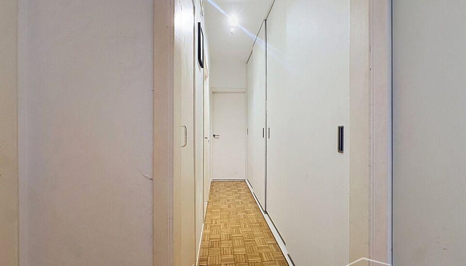Dit aangename gelijkvloerse appartement combineert een praktische indeling met veel lichtinval en fijne buitenruimtes.
Bij binnenkomst verwelkomt de hal met praktische maatkasten u met heel wat extra opbergruimte. De ruime leefruimte biedt plaats voor een