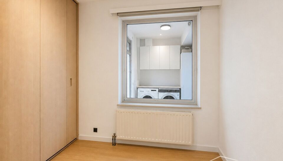 Dit aangename gelijkvloerse appartement combineert een praktische indeling met veel lichtinval en fijne buitenruimtes.
Bij binnenkomst verwelkomt de hal met praktische maatkasten u met heel wat extra opbergruimte. De ruime leefruimte biedt plaats voor een