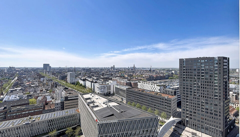 Luxe nieuwbouw appartement op de 20e verdieping met 270 graden uitzicht over Antwerpen, Park Spoor Noord, het Eilandje en de dokken. De lichtrijke leefruimte (ca. 26 m&sup2;) met open  keuken (ca. 6 m&sup2;) is voorzien van een keramische kookplaat, dampkap, koel