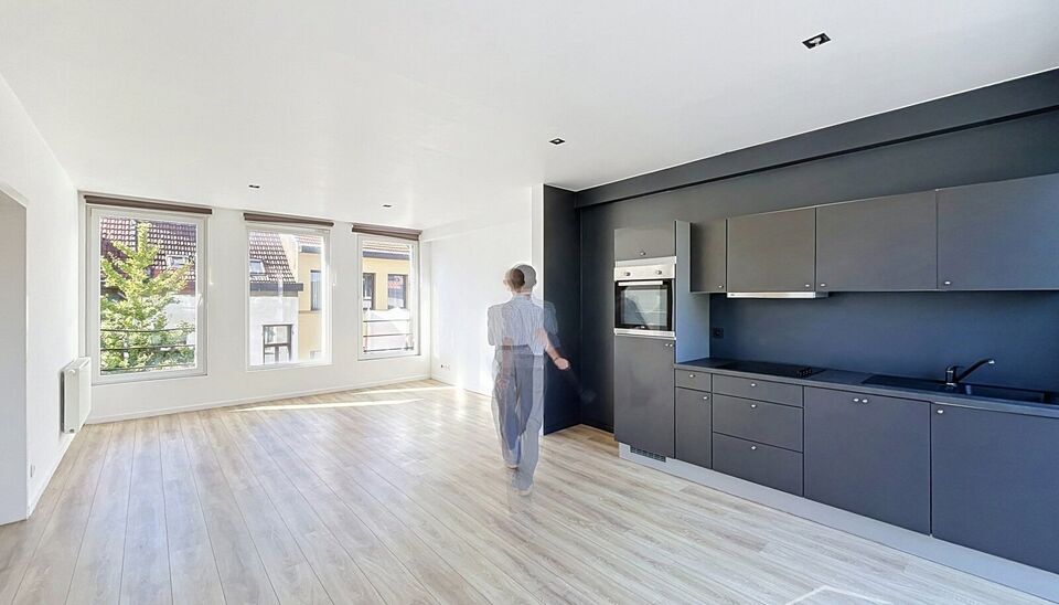 Mooi appartement op de tweede verdieping met een riant terras. Inkomhal, lichtrijke leefruimte (ca 37m&sup2;) met een open ge&iuml;nstalleerde keuken. De moderne keuken is uitgerust met keramische kookplaat, oven, dampkap, vaatwasser en koelkast met vriesvak. Van