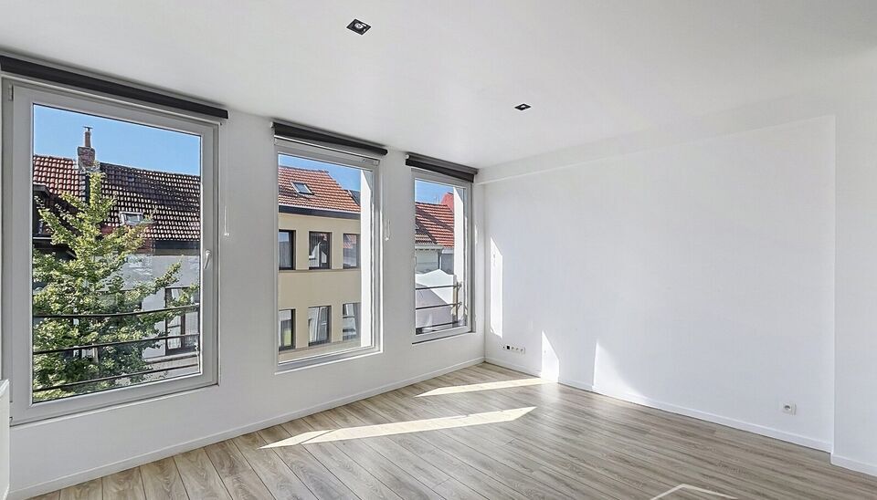 Mooi appartement op de tweede verdieping met een riant terras. Inkomhal, lichtrijke leefruimte (ca 37m&sup2;) met een open ge&iuml;nstalleerde keuken. De moderne keuken is uitgerust met keramische kookplaat, oven, dampkap, vaatwasser en koelkast met vriesvak. Van