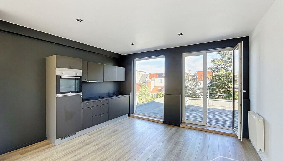 Mooi appartement op de tweede verdieping met een riant terras. Inkomhal, lichtrijke leefruimte (ca 37m&sup2;) met een open ge&iuml;nstalleerde keuken. De moderne keuken is uitgerust met keramische kookplaat, oven, dampkap, vaatwasser en koelkast met vriesvak. Van