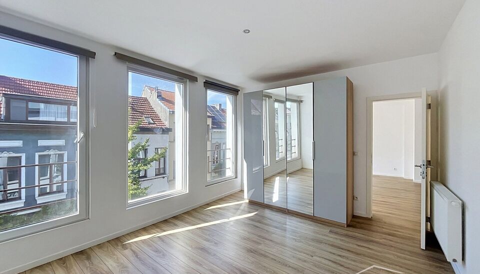 Mooi appartement op de tweede verdieping met een riant terras. Inkomhal, lichtrijke leefruimte (ca 37m&sup2;) met een open ge&iuml;nstalleerde keuken. De moderne keuken is uitgerust met keramische kookplaat, oven, dampkap, vaatwasser en koelkast met vriesvak. Van