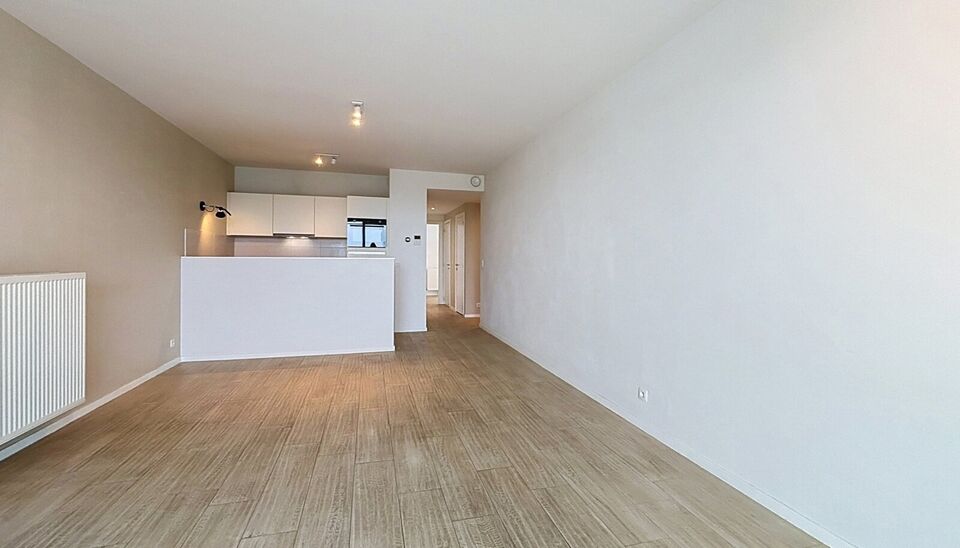 Dit energiezuinig appartement bevindt zich in een recent gebouw (2018) nabij het prachtige Rivierenhof. U betreedt het appartement via de inkomhal (ca.7 m&sup2;) met voldoende kastruimte en apart toilet. Lichtrijke woonkamer op keramische parket met een open 