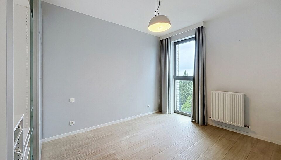 Dit energiezuinig appartement bevindt zich in een recent gebouw (2018) nabij het prachtige Rivierenhof. U betreedt het appartement via de inkomhal (ca.7 m&sup2;) met voldoende kastruimte en apart toilet. Lichtrijke woonkamer op keramische parket met een open 