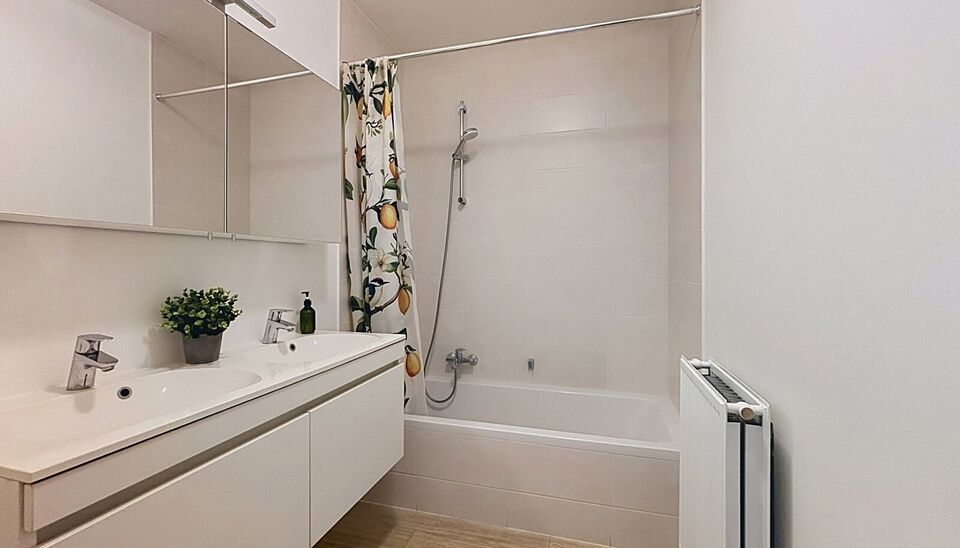 Dit energiezuinig appartement bevindt zich in een recent gebouw (2018) nabij het prachtige Rivierenhof. U betreedt het appartement via de inkomhal (ca.7 m&sup2;) met voldoende kastruimte en apart toilet. Lichtrijke woonkamer op keramische parket met een open 