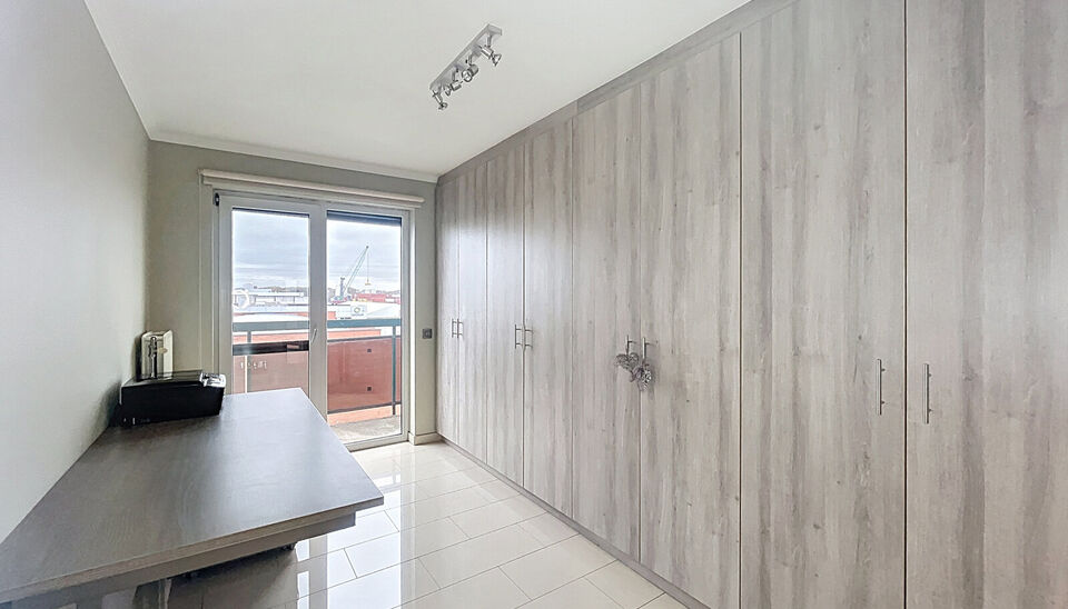 Dit ruime en goed onderhouden appartement met twee slaapkamers is gelegen op een centrale ligging nabij winkels, openbaar vervoer en vele uitvalswegen. Bij binnenkomst wordt u verwelkomd door een inkomhal met maatkast. De woon- en eetkamer, met een opperv