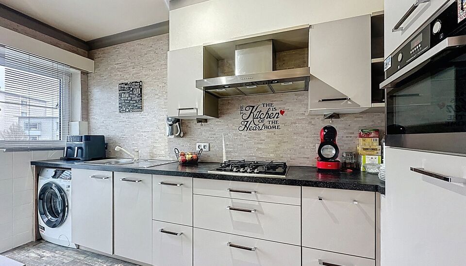 Dit appartement op de tweede verdieping werd recent gerenoveerd. Via de inkomhal bereik je vooraan de lichte woonkamer op tegelvloer. Aansluitend de ingerichte keuken uitgerust met gaskookfornuis, dubbele spoelbak, oven, koelkast met vriesvak en voldoende