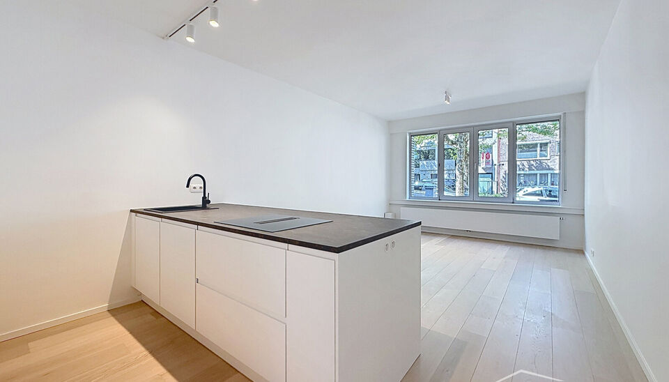 Luxueus gelijkvloers appartement met ruime zonnige tuin in de geliefde Vogeltjeswijk. Dit volledig gerenoveerde gelijkvloerse appartement combineert hedendaags comfort met een uitstekende ligging. Via de inkomhal met kvestiaire bereikt u de lichtrijke lee
