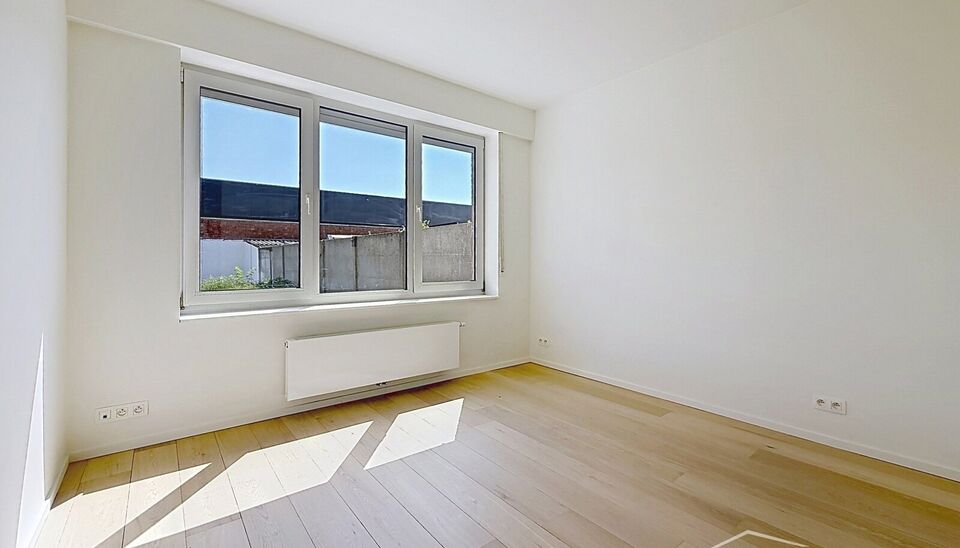Luxueus gelijkvloers appartement met ruime zonnige tuin in de geliefde Vogeltjeswijk. Dit volledig gerenoveerde gelijkvloerse appartement combineert hedendaags comfort met een uitstekende ligging. Via de inkomhal met kvestiaire bereikt u de lichtrijke lee