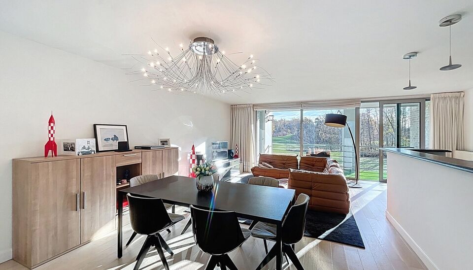 Lichtovergoten en zonnig appartement met een prachtig open uitzicht op de holes van de Golf van Brasschaat. Bij binnenkomst een ruime inkomhal met apart toilet. De uitnodigende woon- en eetkamer op parketvloer (ca. 37m&sup2;), biedt toegang tot het zonnige in