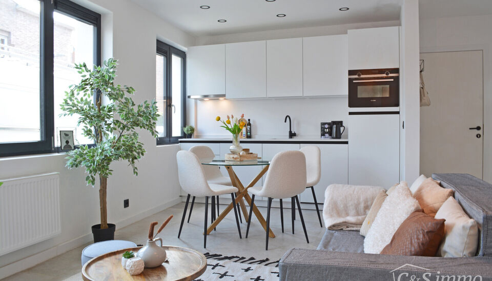 Laatse unit te koop met mooi rendement
Stap binnen in dit smaakvol afgewerkte appartement, gelegen in een klasse vol gerenoveerd gebouw op wandelafstand van het centrum van Edegem.
De inkomhal biedt directe toegang tot de moderne open keuken, volledig uit