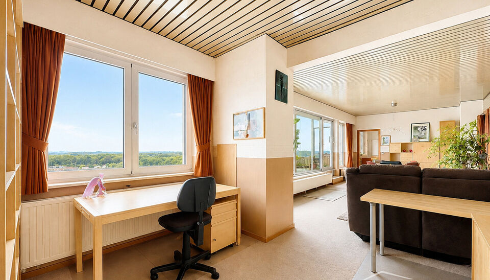 Dit lichtrijke appartement op de 16de verdieping biedt een uniek panoramisch uitzicht over de skyline van Antwerpen. Bij binnenkomst word je verwelkomd in een ruime inkomhal met praktische maatkast en directe toegang tot alle ruimtes.

De woonkamer geniet