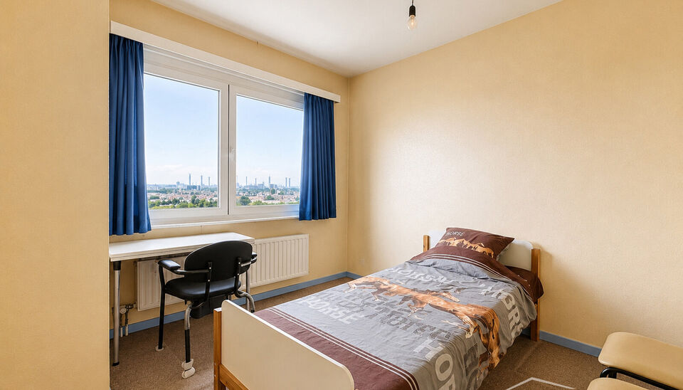 Dit lichtrijke appartement op de 16de verdieping biedt een uniek panoramisch uitzicht over de skyline van Antwerpen. Bij binnenkomst word je verwelkomd in een ruime inkomhal met praktische maatkast en directe toegang tot alle ruimtes.

De woonkamer geniet