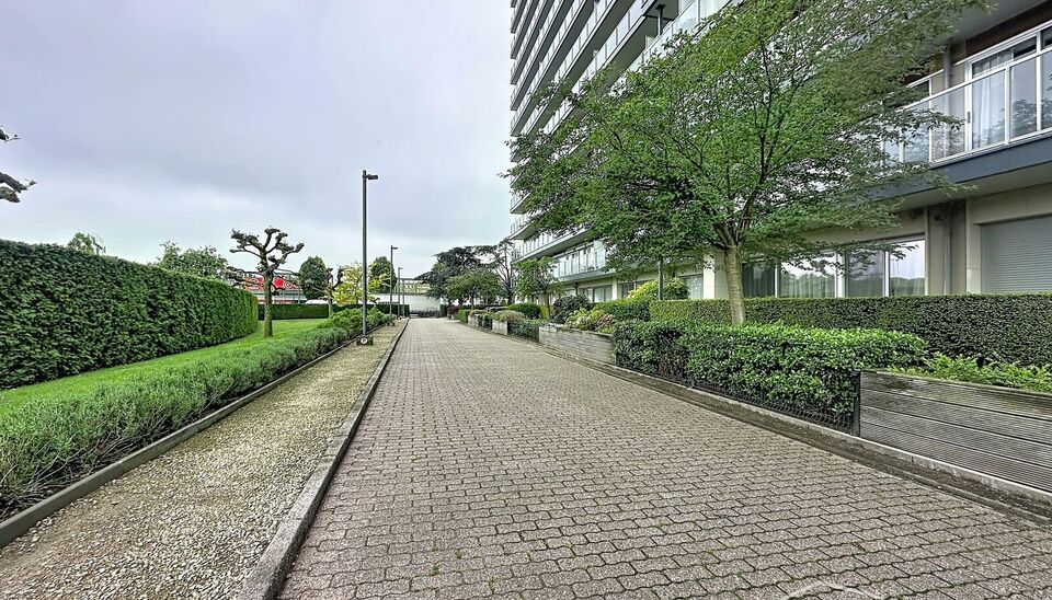 Dit lichtrijke appartement op de 16de verdieping biedt een uniek panoramisch uitzicht over de skyline van Antwerpen. Bij binnenkomst word je verwelkomd in een ruime inkomhal met praktische maatkast en directe toegang tot alle ruimtes.

De woonkamer geniet