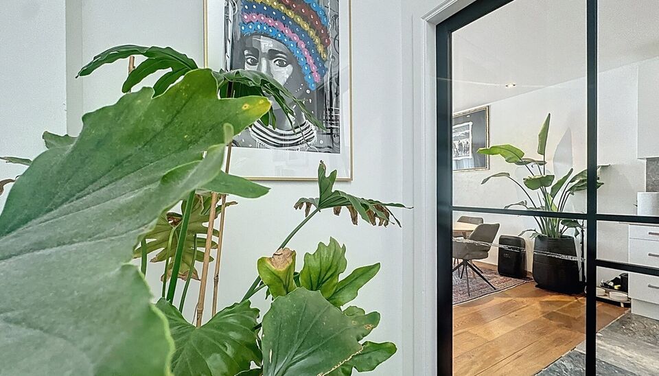 In een charmant gebouw met herenhuis-allure ontdek je deze unieke duplexwoning die eerder dienst deed als twee aparte appartementen, maar nu stijlvol werd samengevoegd tot een ruimtelijke gezinswoning vol karakter.
Via de aparte privé-inkomhal stap je bi