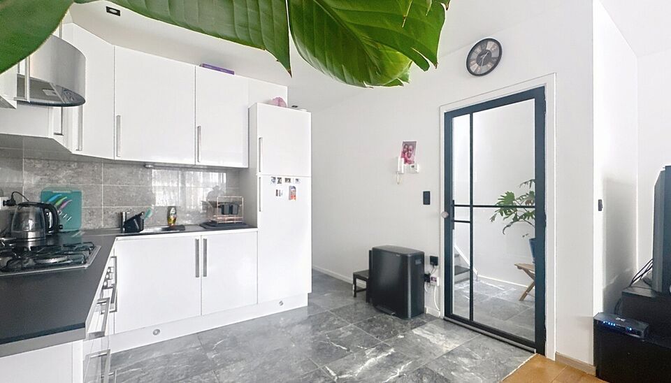 In een charmant gebouw met herenhuis-allure ontdek je deze unieke duplexwoning die eerder dienst deed als twee aparte appartementen, maar nu stijlvol werd samengevoegd tot een ruimtelijke gezinswoning vol karakter.
Via de aparte privé-inkomhal stap je bi
