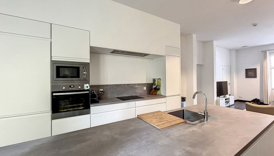 Uniek gerenoveerd 1-slaapkamer appartement (ca.90m&sup2;) in authentiek gebouw aan 'den Dam'. Ruime en lichte woonkamer (ca. 30m&sup2;) op keramische tegel. Aansluitend open keuken met kookeiland (ca. 18m&sup2;), deze is volledig uitgerust met kwaliteitsvolle toestel