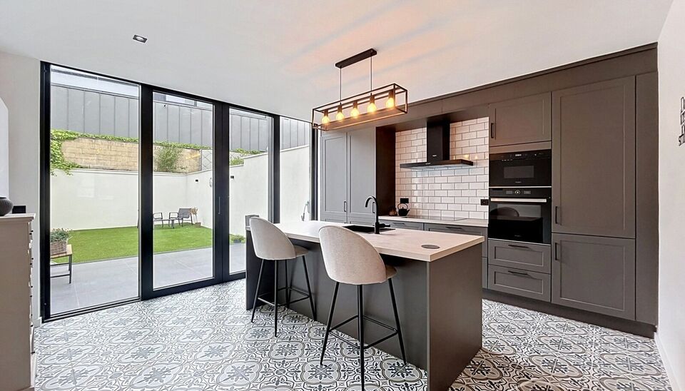 Stijlvol en energiezuinig herenhuis met ruime tuin en mogelijkheid tot vier slaapkamers, rustig gelegen aan de Dam op wandelafstand van Park Spoor Noord.
De woning verwelkomt u met een inkomhal met hoge plafonds en gastentoilet. De lichtrijke leefruimte m
