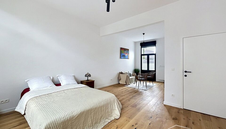 Stijlvol en energiezuinig herenhuis met ruime tuin en mogelijkheid tot vier slaapkamers, rustig gelegen aan de Dam op wandelafstand van Park Spoor Noord.
De woning verwelkomt u met een inkomhal met hoge plafonds en gastentoilet. De lichtrijke leefruimte m