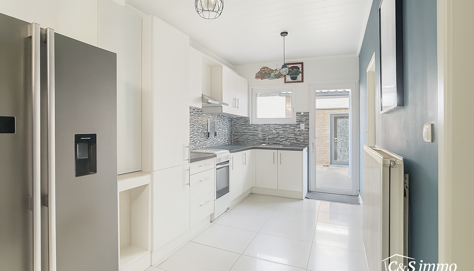 Stap binnen in deze gezellige woning met drie slaapkamers en tuin. Via de gezellige inkomhal komt u binnen in de leefruimte. U kan genieten van een open ruimte van maar liefst 40m² geaccentueerd met sierhaard. Achteraan de woning een ruime keuken met vee