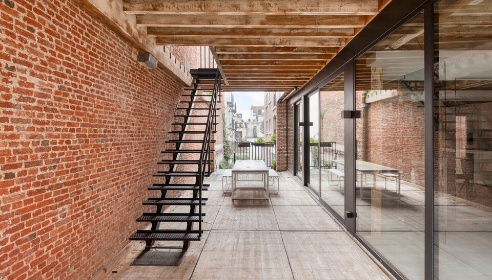 Welkom in Magazijn Julia &ndash; een voormalig pakhuis met paardenstallen en smidse, ontworpen in 1876 door Charles De Coster en gebouwd in een kenmerkende eclectische stijl. In dit monumentale gebouw bevindt zich op de eerste verdieping een luxueuze kantoor-