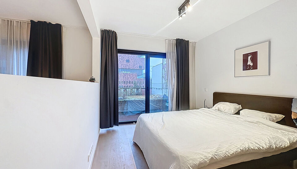 Dit stijlvol afgewerkt studioappartement op de eerste verdieping combineert comfort, licht en een topligging op een boogscheut van het MAS en het bruisende Eilandje. 
De leefruimte met open keuken (32 m&sup2;) is volledig voorzien van hoogwaardige parketvloer